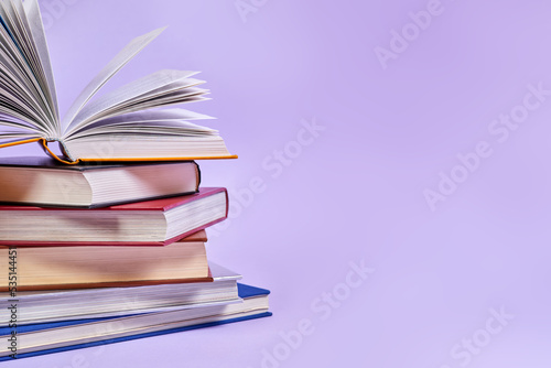 Close-up of a stack of books with one open book on top