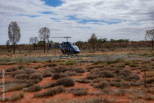 Passengers getting ready for a helicopter ride on a cloudy day at Ayers Rock Uluru-Kata Tjuta in Northern Territory, Australia. Valley of the winds photo