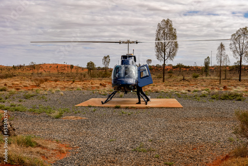 Canvas-taulu Passengers getting ready for a helicopter ride on a cloudy day at Ayers Rock Uluru-Kata Tjuta in Northern Territory, Australia