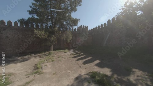 FPV: POV perspective aerial flies from dark room into castle courtyard