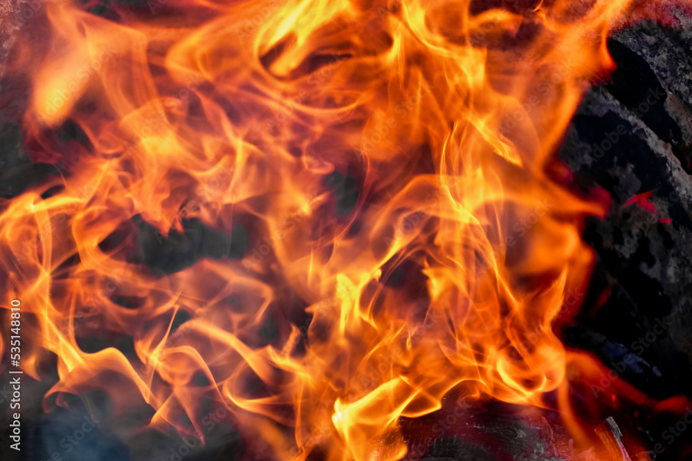 Burning fire close up. Bright orange and red flames on a dark background. Open flame heating. Problems with heating and gas.