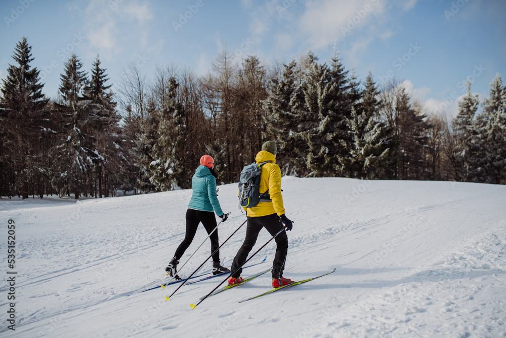 Senior couple skiing togetherin the middle of forest