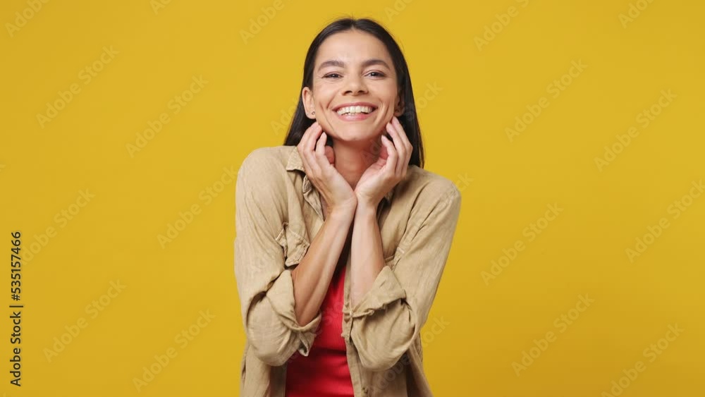 Side profile view surprised young latin woman wearing beige shirt pink t-shirt turn around camera cover mouth with hands on face say wow omg no way isolated on plain yellow background studio portrait Side profile view surprised young latin woman wearing beige shirt pink t-shirt turn around camera cover mouth with hands on face say wow omg no way isolated on plain yellow background studio portrait