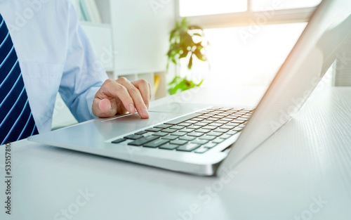 Close-up of businessman using laptop computer in office