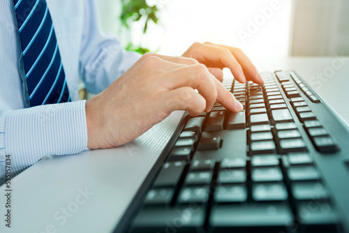 Male office worker typing on the keyboard
