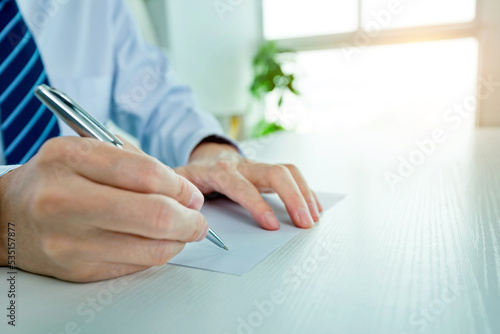 Businessman hand writing on a paper