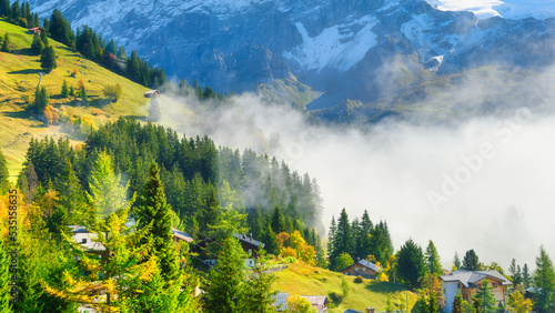 A village in Switzerland. A sunny day and a mountain valley. Houses against a...