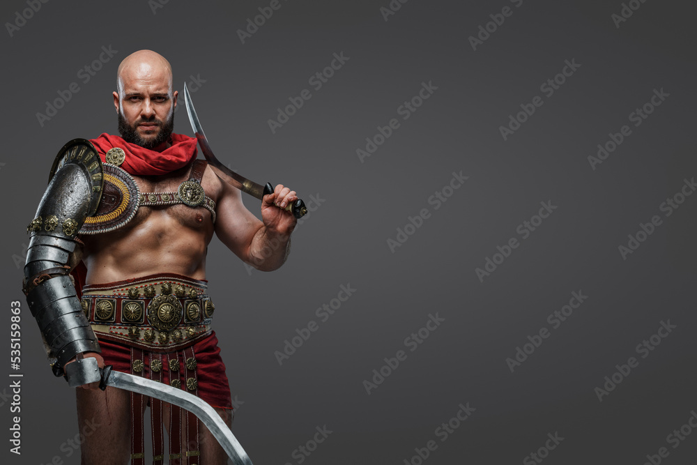 Shot of roman gladiator from ancient rome dressed in armor and cloak against gray background. Shot of roman gladiator from ancient rome dressed in armor and cloak against gray background.