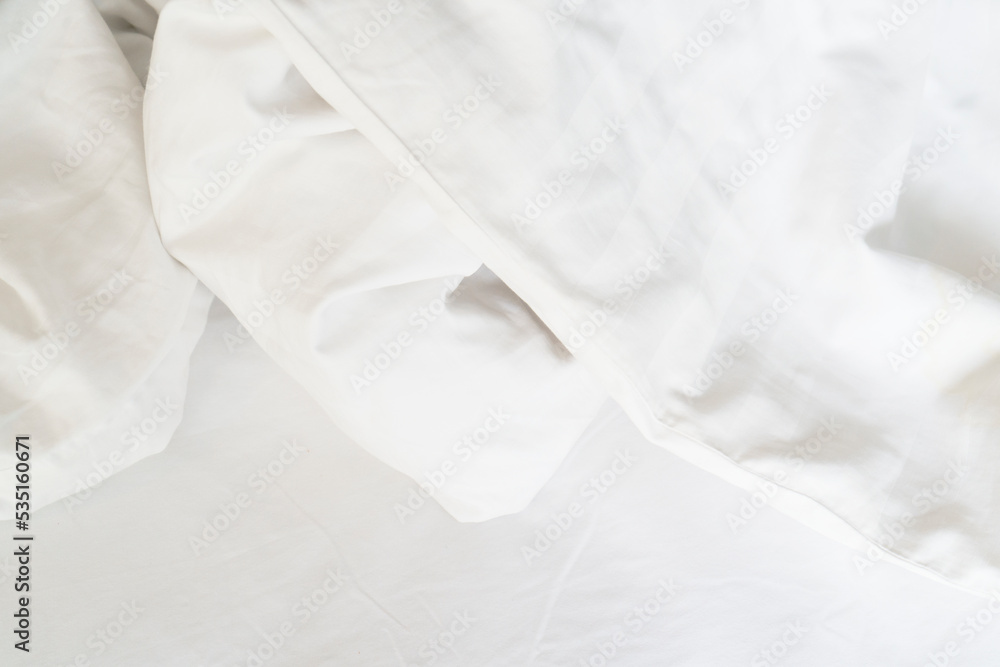 Obraz premium Unmade bed; wrinkled pillowcases, bed sheet and duvet