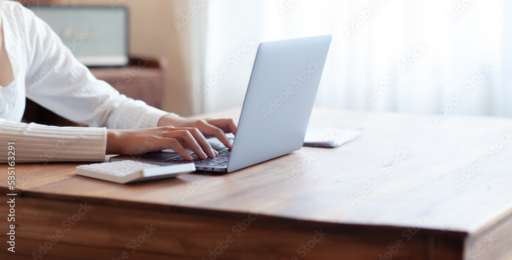 business woman drinking coffee and working on wooden table at home Using a laptop and computer to assess and analyze the economy to invest successfully in his own business, business ideas. business woman drinking coffee and working on wooden table at home Using a laptop and computer to assess and analyze the economy to invest successfully in his own business, business ideas.
