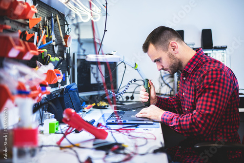 Photography IT engineer technician repairing computer in electronics service shop