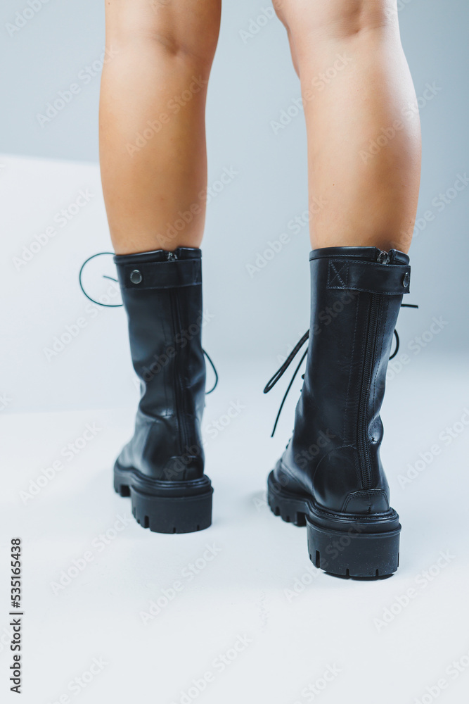 Close-up of female legs in black leather lace-up shoes. New autumn collection of women's leather shoes 2022 Close-up of female legs in black leather lace-up shoes. New autumn collection of women's leather shoes 2022