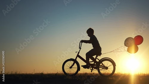 Wallpaper Mural kid silhouette bike riding on a park. kid boy rides a bike in nature in the park on the road. happy family kid dream concept. son plays a bike rides on a sandy road lifestyle Torontodigital.ca