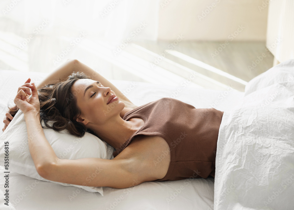 Young woman sleeping in bed. Cute woman in bedroom at home. Relaxation, resting, self care, healthy lifestyle, bedtime concept Young woman sleeping in bed. Cute woman in bedroom at home. Relaxation, resting, self care, healthy lifestyle, bedtime concept