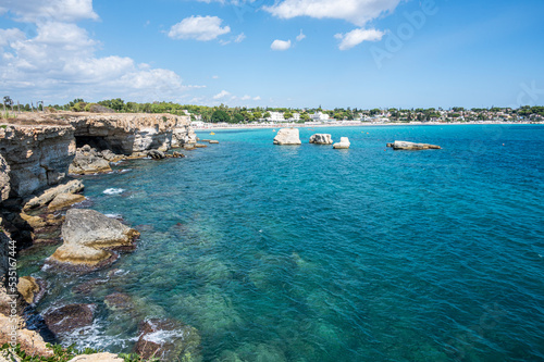 beautiful cliff with clear and crystalline turquoise water in Sicily in Syracuse with the beach of Fontane Bianche in the background