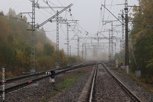 the railway goes into the autumn fog