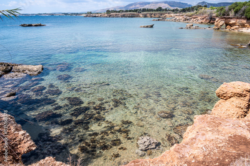 Beautiful beach with crystal clear water and a natural rock arch in the background in Syracuse Sicily © Alessio