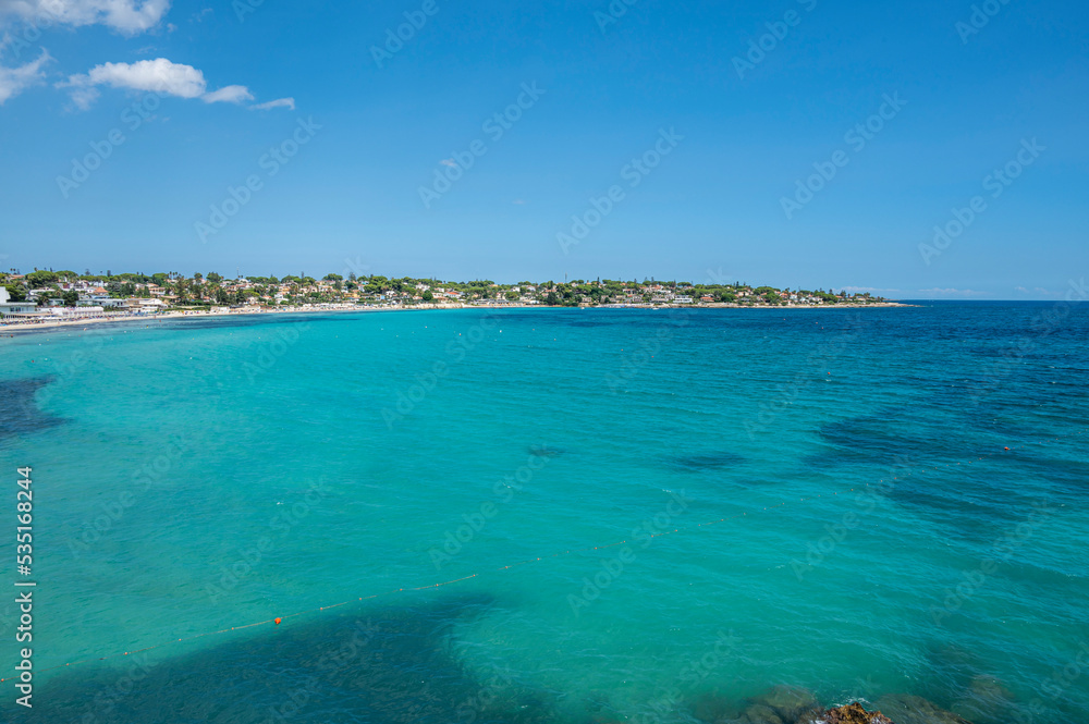 Naklejka premium Landscape of a beautiful beach with clear and crystalline turquoise water and fine sand in Sicily in Syracuse called Fontane Bianche