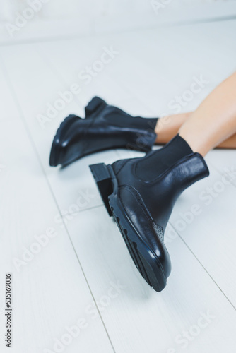 Close up of female legs in black leather Chelsea boots. New autumn collection of women's leather shoes 2022 © Дмитрий Ткачук