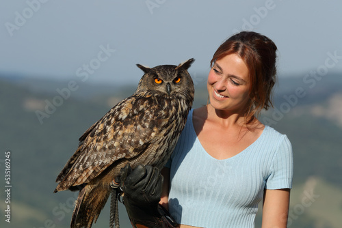Happy falconer looking at eagle owl outdoor