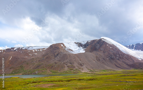 Beautiful nature of rocky mountains and peaks with glaciers. Unusual landscape of nature. Rocks on the background of the sky with clouds. Bad weather cyclone, rainy season, foggy day.