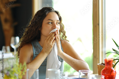 Woman cleaning mouth with a napkin in a restaurant