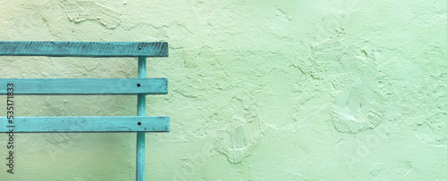 Old wooden bench on timeworn wall surface as copy space and background