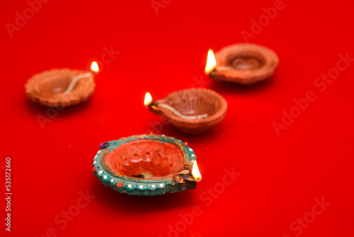 Concept of indian festival diwali. Traditional oil lamps on Red background.