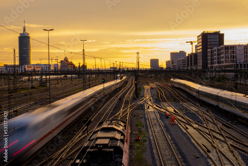 View from the Hackerbrücke (Bridge in Munich) at yellow orange sunset with trains at long exposure