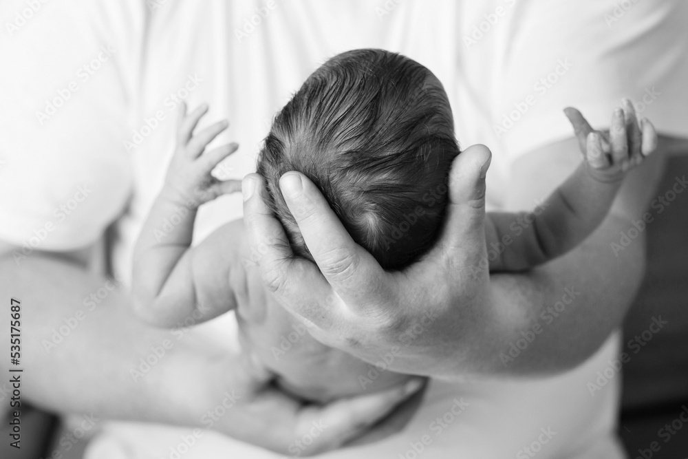 Father holding head of her newborn baby in hands. Loving father hand holding cute sleeping newborn baby child. Beautiful conceptual image of parenthood Father holding head of her newborn baby in hands. Loving father hand holding cute sleeping newborn baby child. Beautiful conceptual image of parenthood