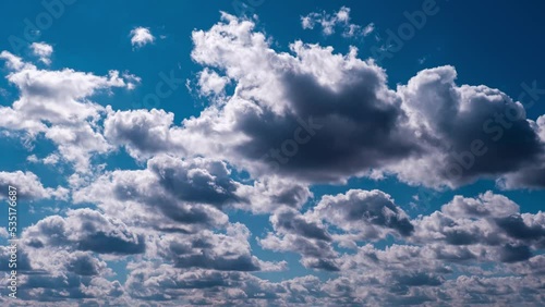 Timelapse of cumulus clouds moving in the blue sky. Summer cloudy space with dark and light clouds changing shape. Atmosphere background, time lapse. Change of weather. Nature, Sky clouds, copy space