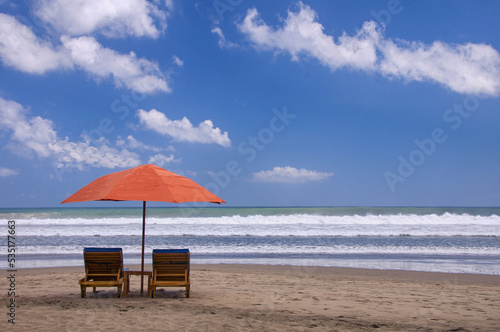 beach umbrella and chairs on a sunyy day © komangastina