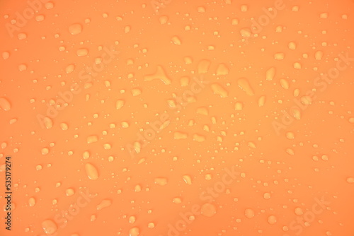 Defocus blurred water drops on orange background. waterdrops detail the background. Water splash  water spray background. Calm orange background with water drop.