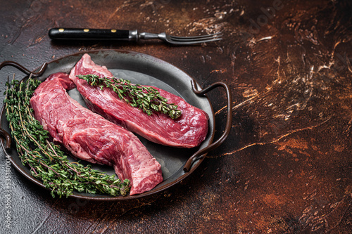 Raw Bavette or Sirloin flap beef meat steak with thyme. Dark background. Top view. Copy space