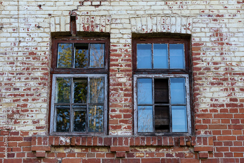 Fototapeta Naklejka Na Ścianę i Meble -  Old windows in the facade of a red brick building