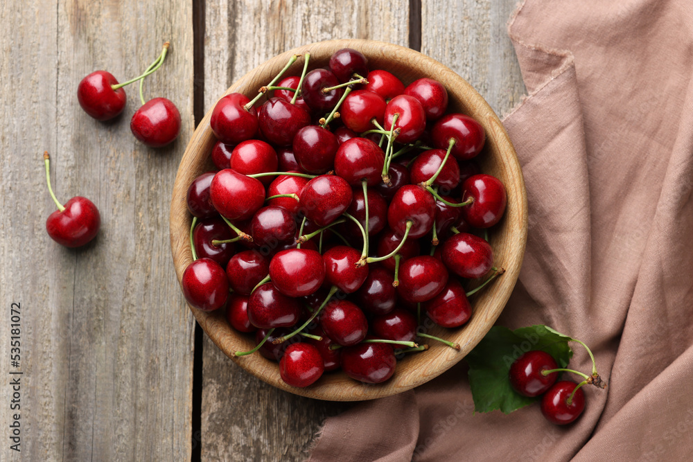 Fresh ripe cherries and towel on wooden table, flat lay Fresh ripe cherries and towel on wooden table, flat lay