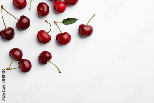 Many sweet ripe cherries on white background, flat lay. Space for text