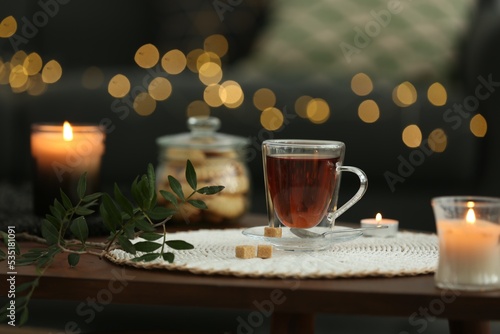 Tea  cookies and decorative elements on wooden table against blurred lights indoors