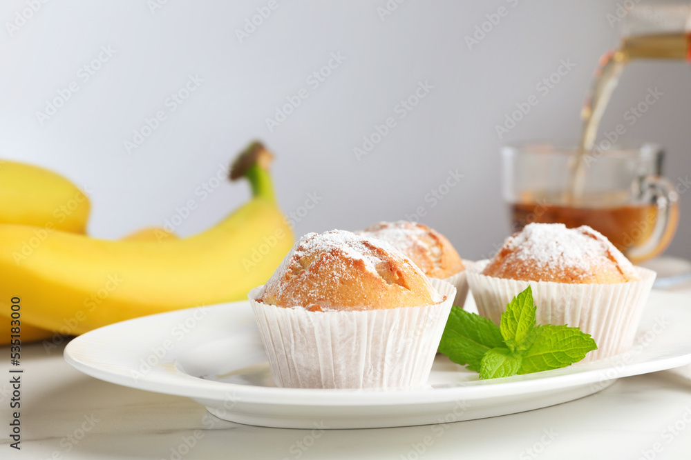 Tasty muffins served with mint on white table, closeup Tasty muffins served with mint on white table, closeup