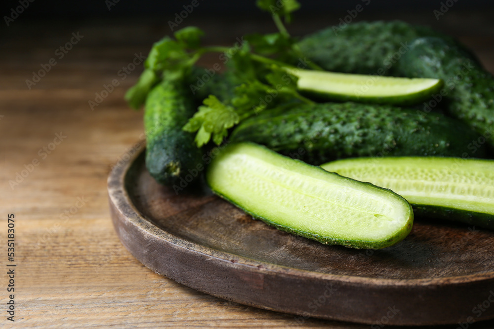 Fresh ripe cucumbers and parsley on wooden table, closeup Fresh ripe cucumbers and parsley on wooden table, closeup