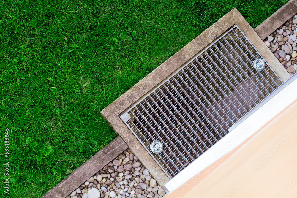 Gutter drain grate, Cover, Grid near the wall of the house on the lawn
