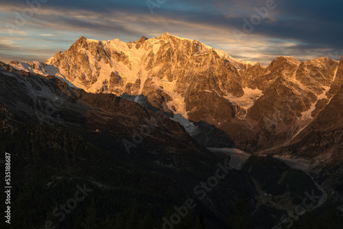Mountain with glacier at sunrise. Monte Rosa in the European alps, Macugnaga, Italy. Spectacular rock and ice wall