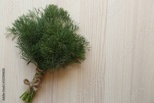 Bunch of dill on white wooden table, top view. Space for text