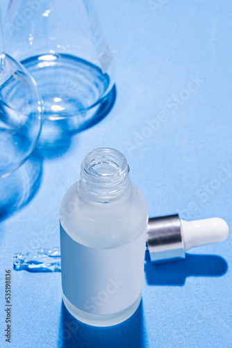 Laboratory equipment with advertising backgrounds. Medical flasks, bowls. Chemical laboratory research of cosmetics. Serums for the face.