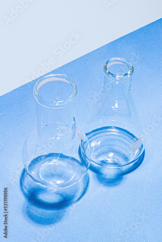Laboratory equipment with advertising backgrounds. Medical flasks, bowls. Chemical laboratory research of cosmetics. Serums for the face.