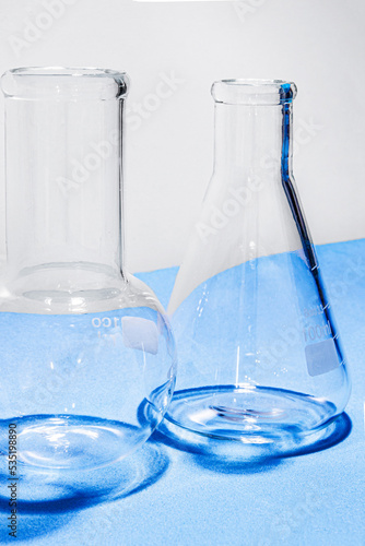 Laboratory equipment with advertising backgrounds. Medical flasks, bowls. Chemical laboratory research of cosmetics. Serums for the face.