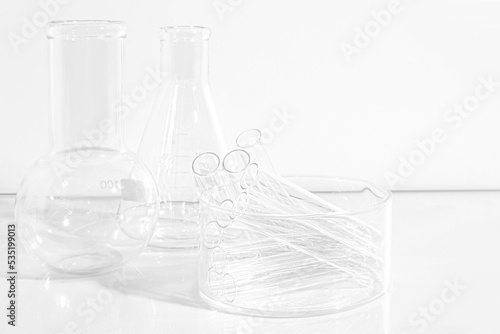 Laboratory equipment with advertising backgrounds. Medical flasks, bowls. Chemical laboratory research of cosmetics. Serums for the face.
