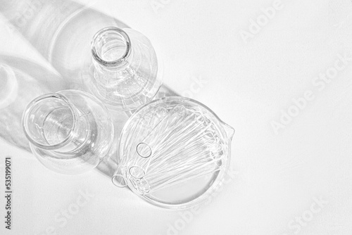 Laboratory equipment with advertising backgrounds. Medical flasks, bowls. Chemical laboratory research of cosmetics. Serums for the face.