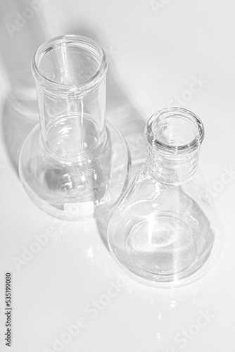 Laboratory equipment with advertising backgrounds. Medical flasks, bowls. Chemical laboratory research of cosmetics. Serums for the face.