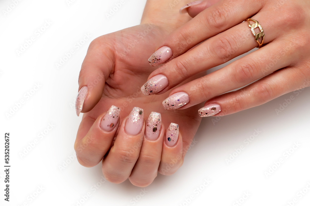 Shiny pink manicure on long square nails close-up on a white background. Shiny pink manicure on long square nails close-up on a white background.